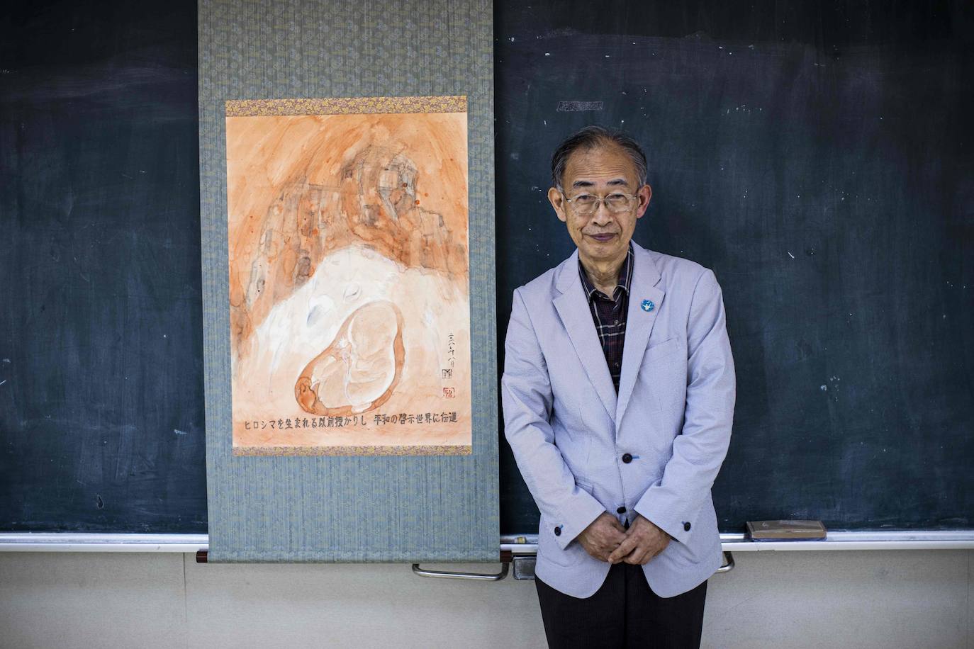 Jiro Hamasumi, cuya madre estaba embarazada de él en Hiroshima cuando cayó la bomba atómica posa junto a una pintura. Se cumplen 75 años desde los devastadores ataques contra Hiroshima y Nagasaki, la última generación de supervivientes de la bomba nuclear está trabajando para garantizar que su mensaje siga vivo después de ellos. El conocimiento de Jiro del ataque de Hiroshima proviene de los relatos de sus hermanos, quienes describieron el relámpago vertiginoso y el rugido desgarrador que formaron la primera indicación de que la bomba conocida como Little Boy había detonado.