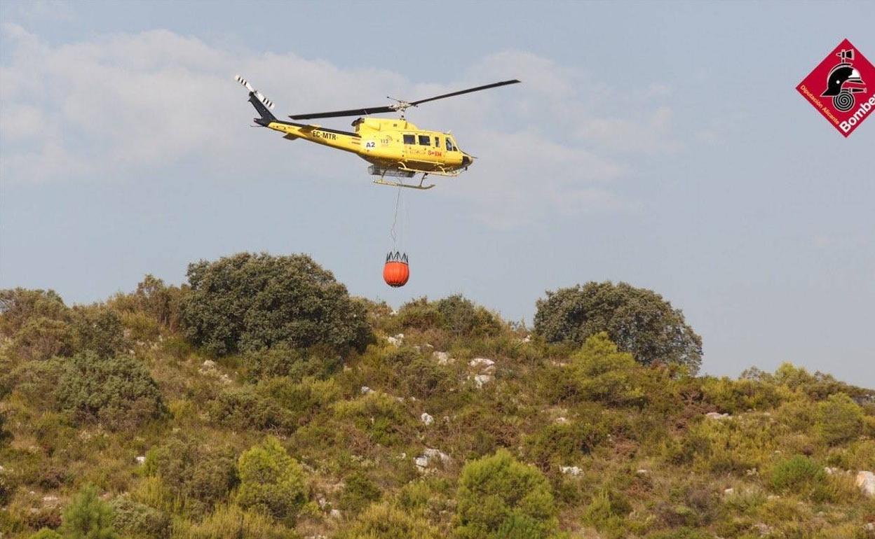 Un helicóptero del Consorcio Provincial de Bomberos trabaja sobre el terreno. 