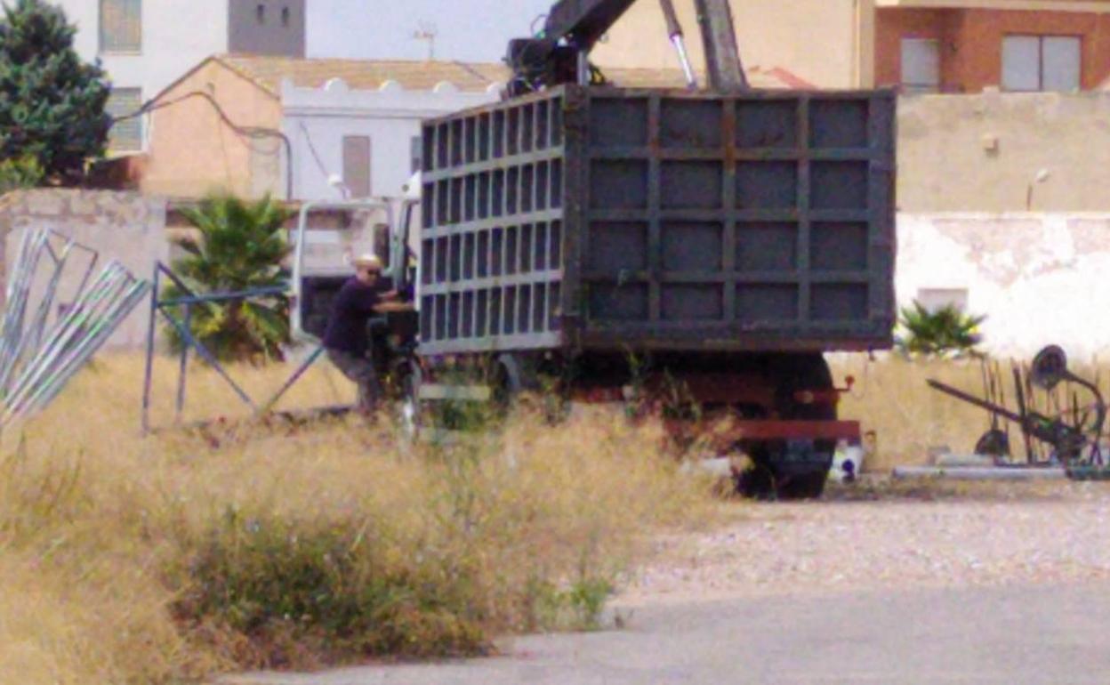 El camión de la empresa de la chatarra se lleva el material que había en un solar. 