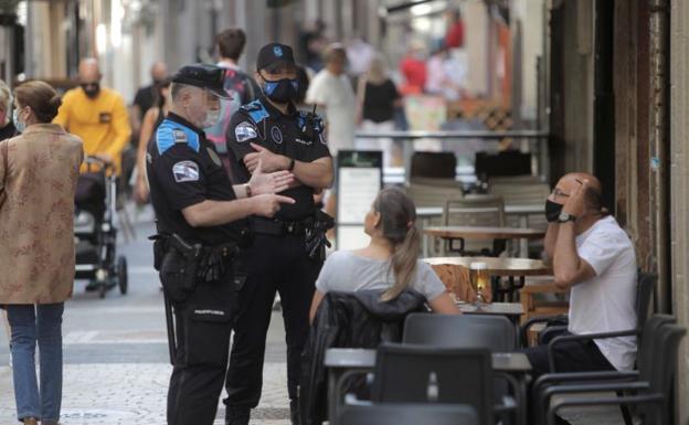 Dos policías municipales vigilan que se cumpla la nueva medida en las calles de A Coruña.