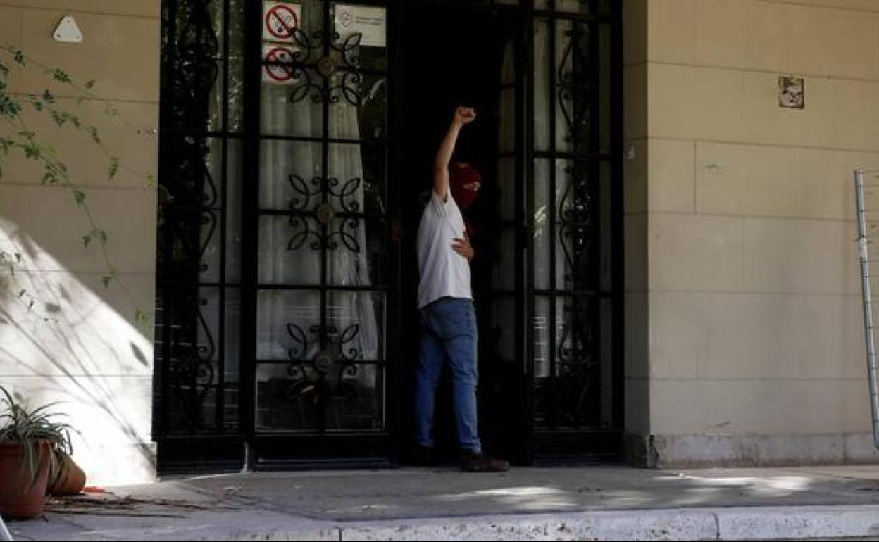 Un okupa con el puño en alto en la ocupación del colegio mayor Lluis Vives.