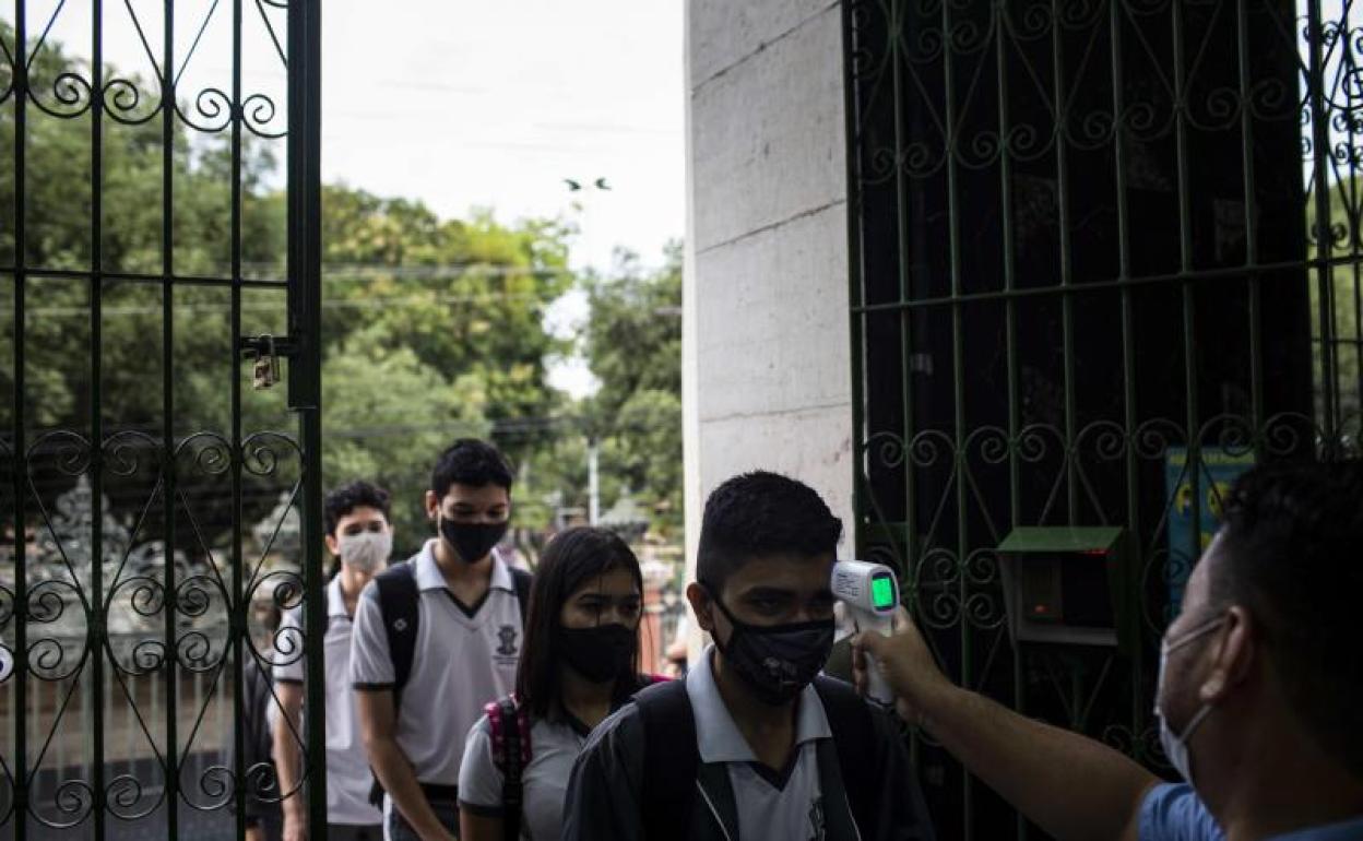 Un guardia le toma la temperatura a los estudiantes durante el inicio de clases en Manaos (Brasil)