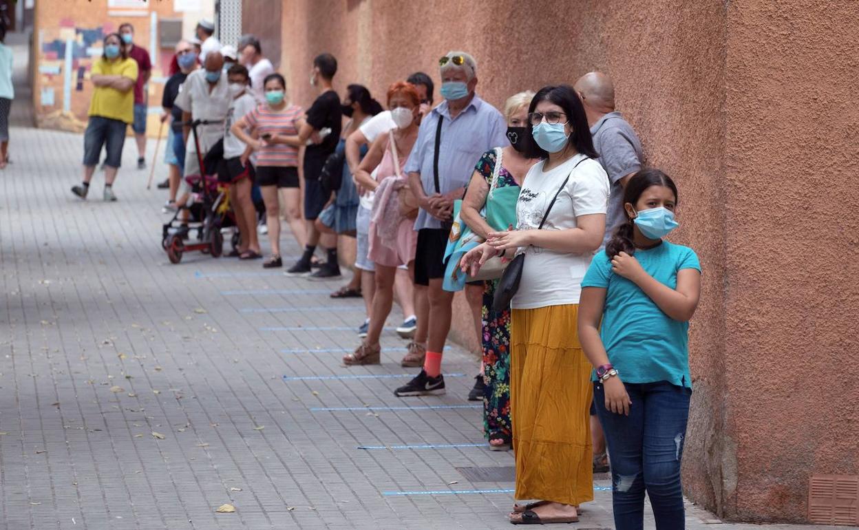 Vecinos de Santa Coloma de Gramanet hacen cola para las pruebas PCR.