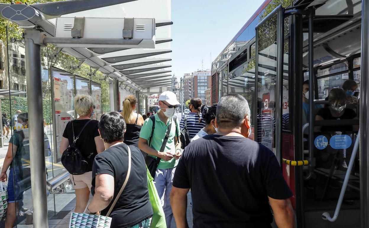 Un grupo de personas en una parada de la EMT en Valencia. 