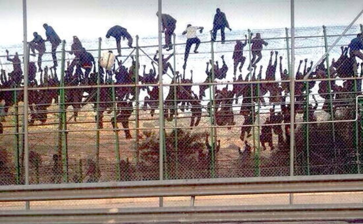 Imagen de archivo de un salto masivo de la valla de Melilla.