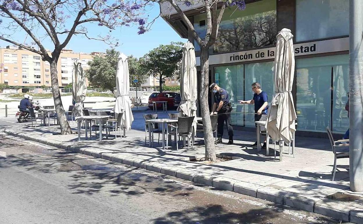 Agentes de la Policía Local de Alicante miden la distancia entre mesas en una terraza. 