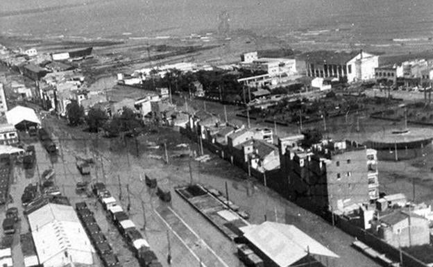 La riada de 1957 se adueña del paisaje sobre los terrenos ferroviarios del Grao; al fondo, la playa y Las Arenas.