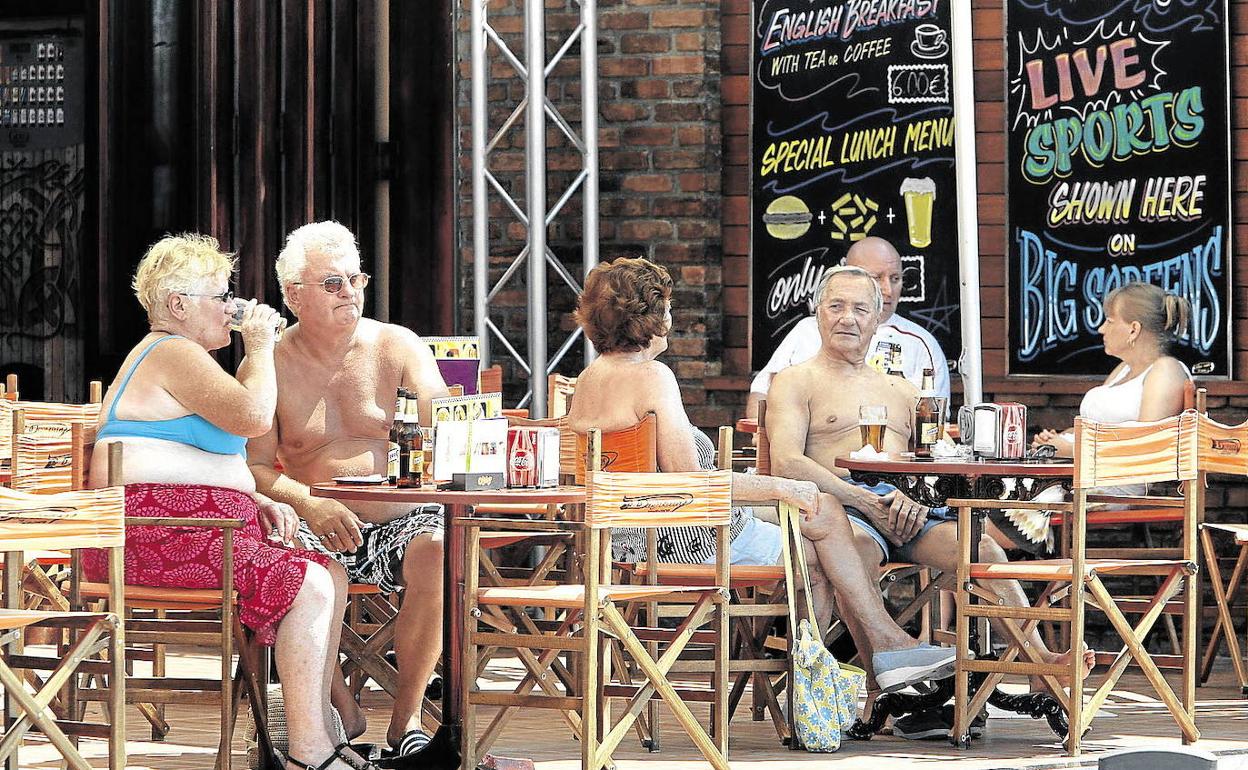 Varios turistas se refrescan en una terraza de la playa de Levante de Benidorm. 