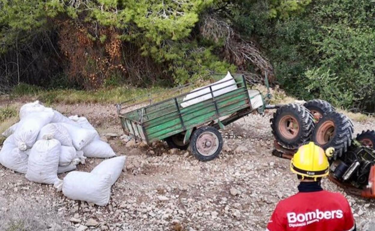 Un bombero supervisa un accidente de un tractor que se saldó también con el fallecimiento del conductor. 