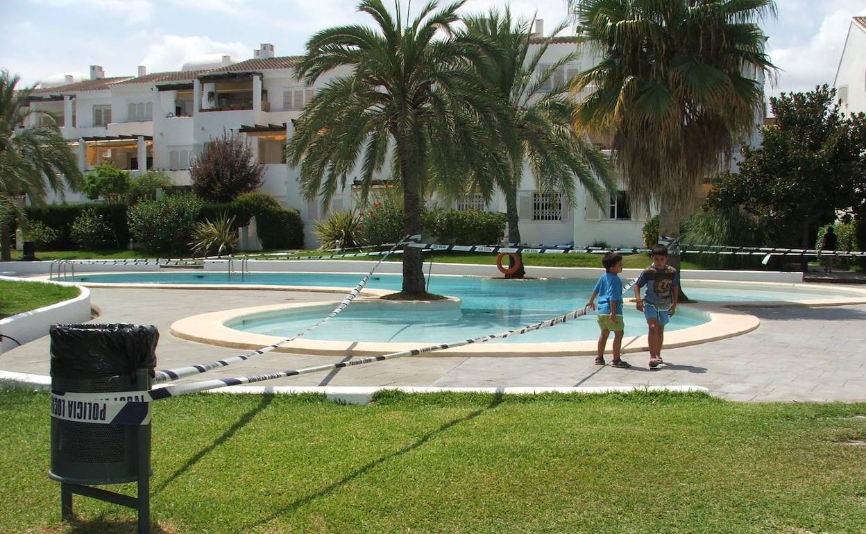 Imagen de una piscina de una urbanización acordonada por la Policía. 