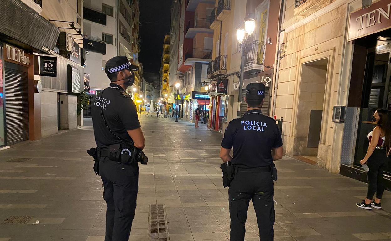 Dos agentes comprueban que se cumplan las normas de seguridad en la calle Castaños de Alicante. 