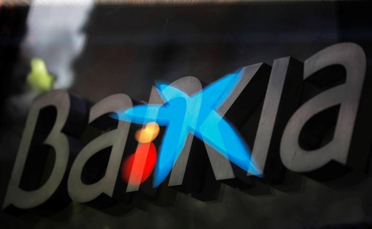 Fotografía de multiexposición que muestra los logotipos de las entidades bancarias Bankia y CaixaBank.