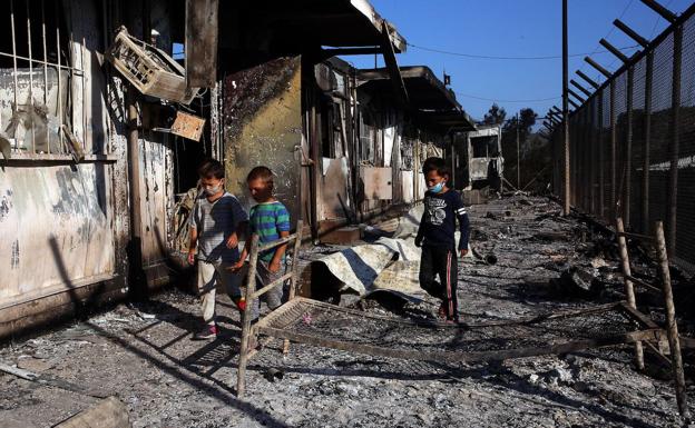 Unos niños caminan entre los restos del campo de refugiado de Moría, en la isla de Lesbos (Grecia).