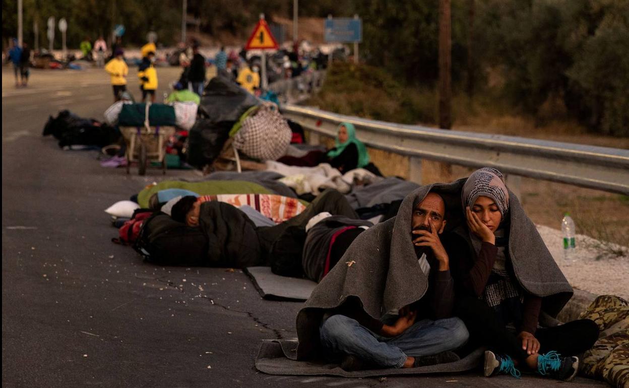 Los inmigrantes del campamento arrasado por el fuego en la isla de Lesbos (Grecia) pasaron la noche tirados en una carretera.