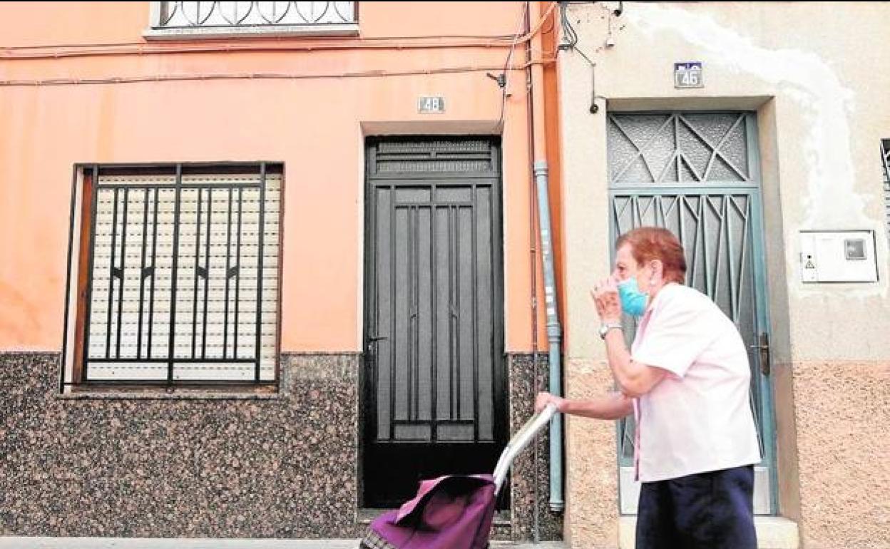 Un mujer empuja su carro junto a la casa donde vivía la pareja. 