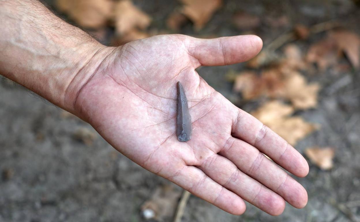 Uno de los participantes muestra en la palma de su mano uno de los restos hallados en la campaña de excavaciones de este año en el yacimiento neolítico de La Draga en Banyoles (Girona)