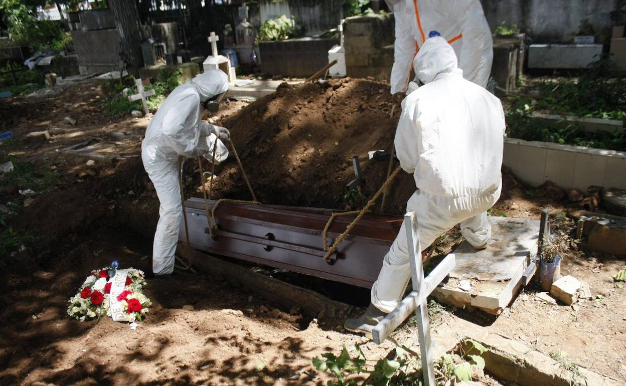 Trabajadores gubernamentales entierran una víctima de Covid-19 en Venezuela.