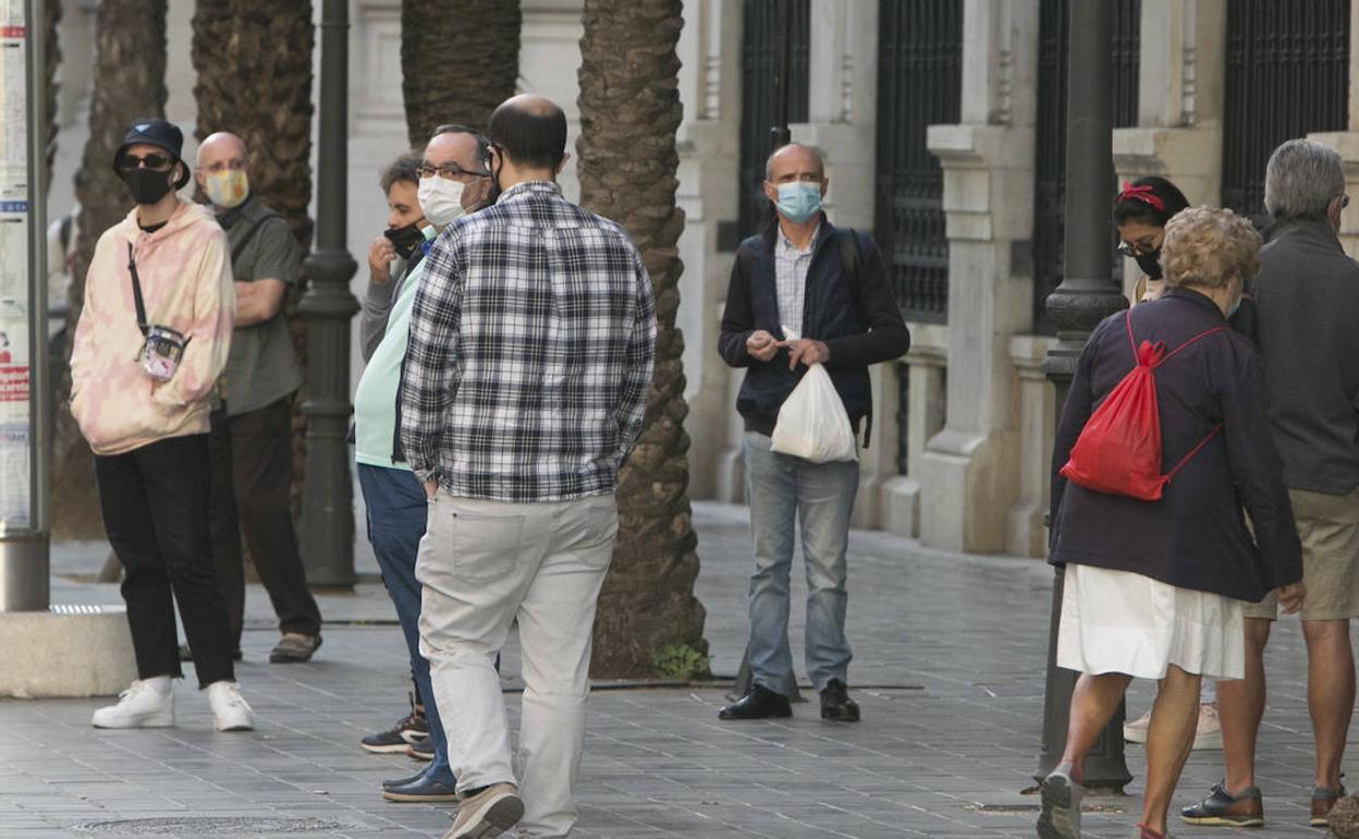 Un grupo de personas esperan al autobús en Valencia