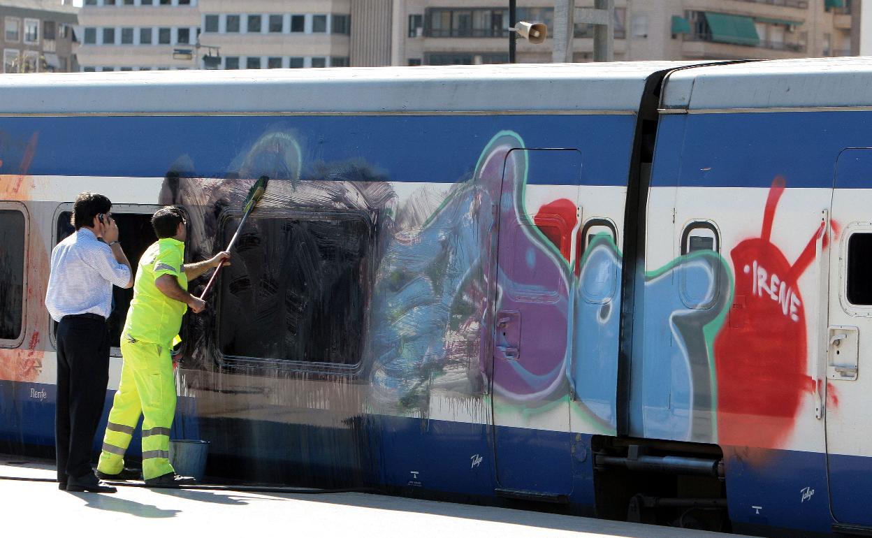 Un trabajador limpia un grafiti en un tren. 