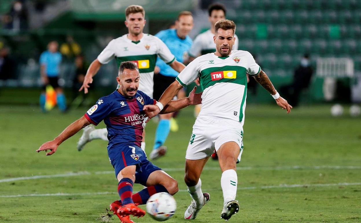 El zaguero del Elche Josema tapona el lanzamiento del jugador del Huesca David Ferreiro. 