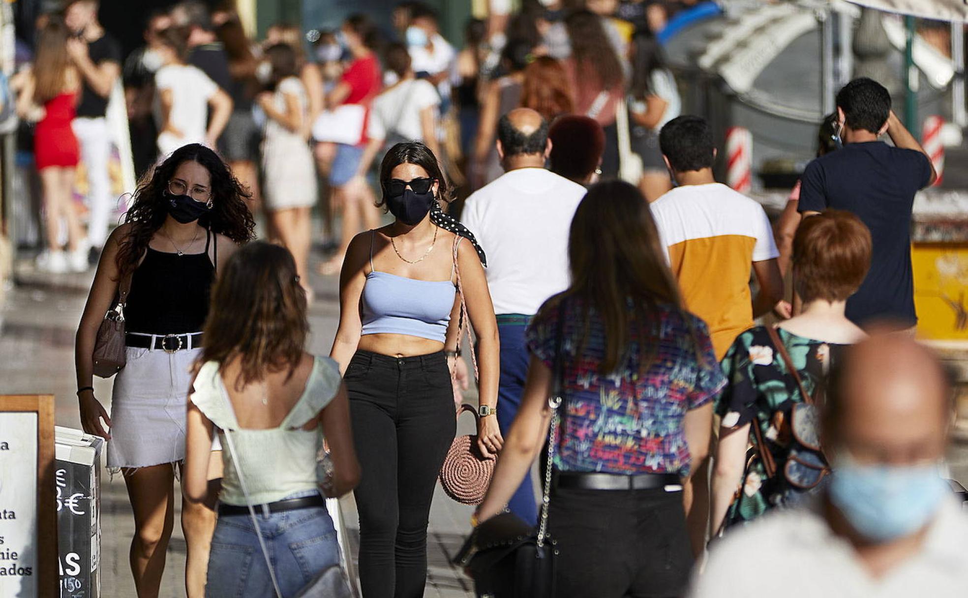 Ciudadanos deambulan por las aceras con sus mascarillas.