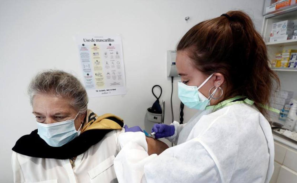 Una mujer se vacuna contra la gripe. 