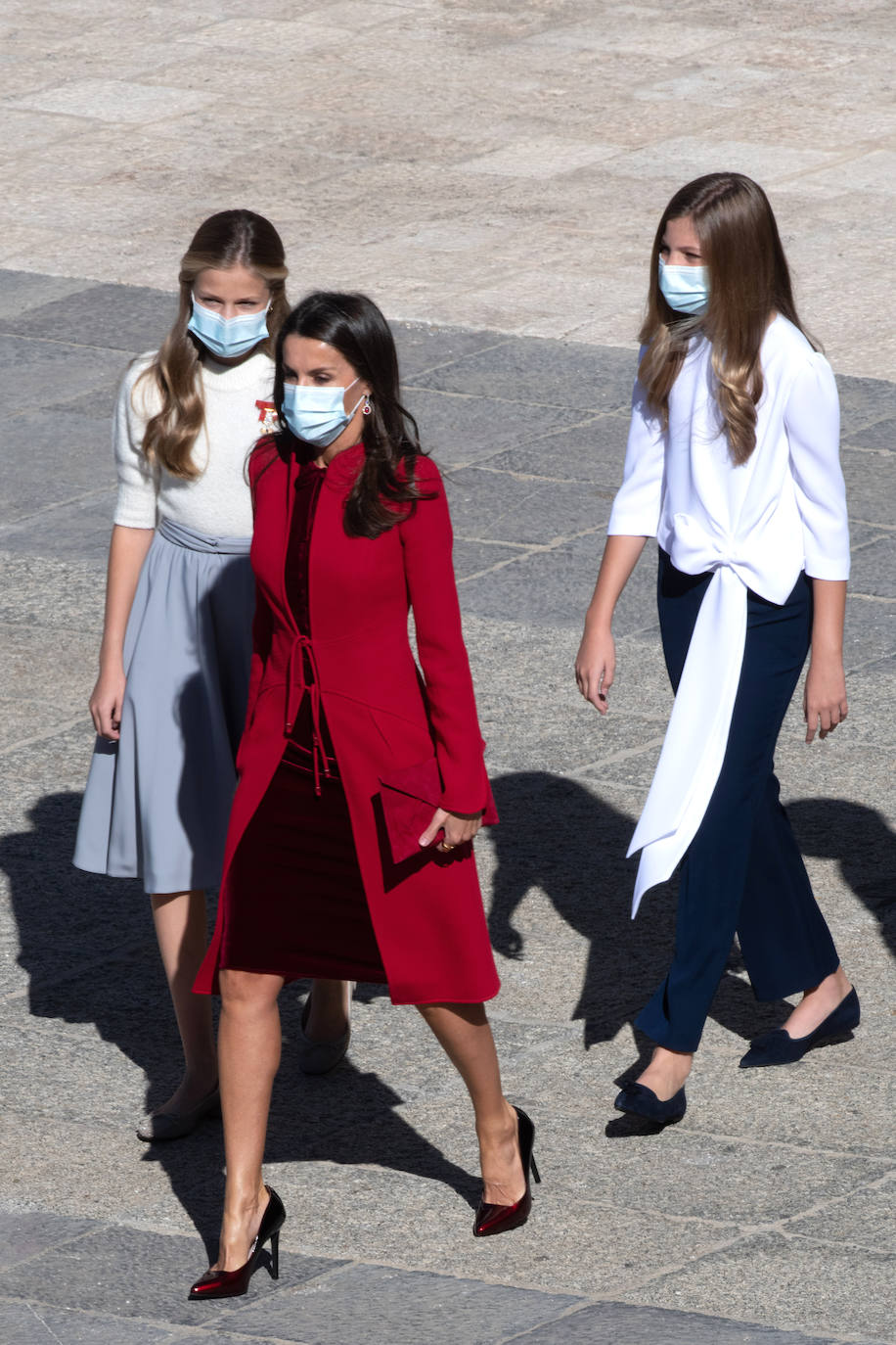 La Reina Letizia, la Princesa Leonor y la Infanta Sofía han sido también protagonistas en el acto de celebración del Día de la Fiesta Nacional, celebrado este lunes en la plaza de la Armería del Palacio Real de Madrid. Doña Letizia ha rescatado un sobrio dos piezas de Felipe Varela que lleva en su ropero desde hace años, formado por un vestido de terciopelo con botones y un abrigo recto en crepe que se abrocha con pequeños lazos. La Princesa Leonor, que a finales de este mes cumplirá 15 años, ha sorprendido con una falda abullonada y un cuerpo con mangas de farol, en tonos pastel. Su hermana, la Infanta Sofía, mucho más sobria, ha estrenado este 12-O un pantalón ancho y una camisola con gran lazada. 