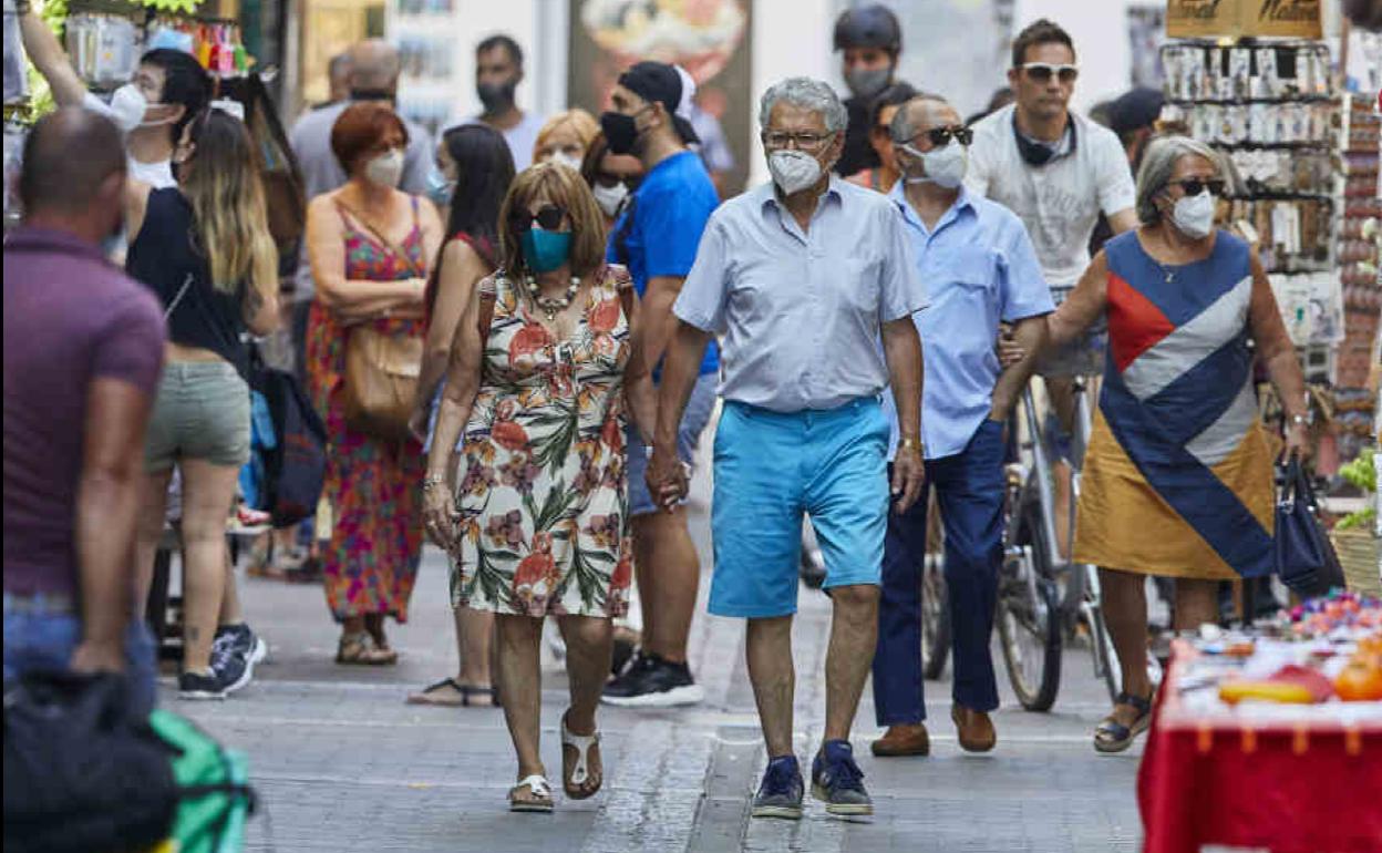 Gente paseando por una calle de Valencia.