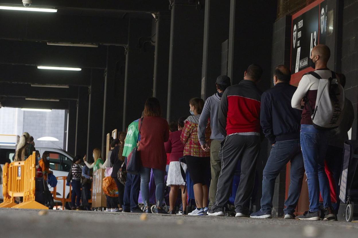 Colas ayer en Mestalla para recibir un lote de comida del Banco de Alimentos. iván arlandis