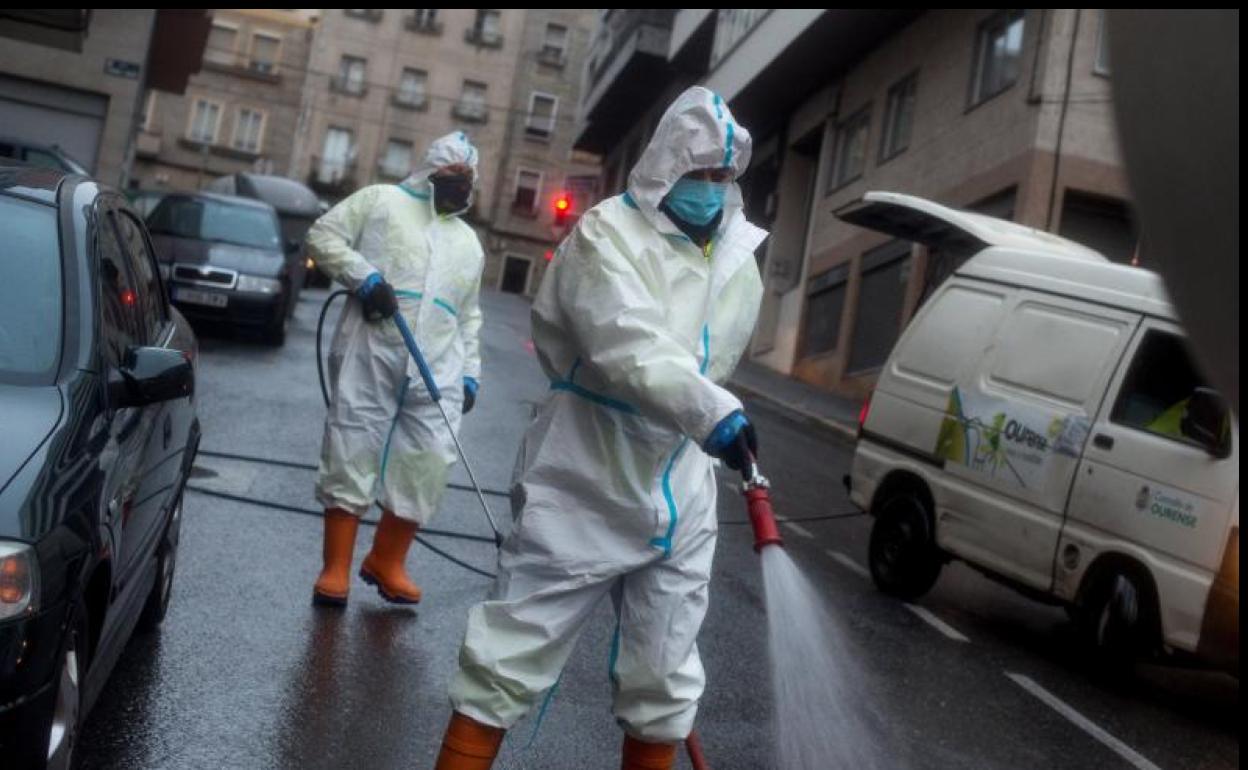 Operarios municipales realizan labores de desinfección en una calle de Ourense. 