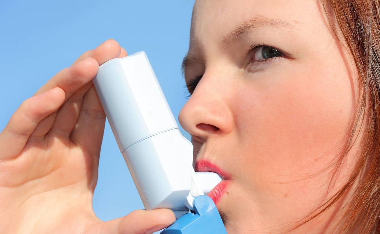 Joven asmática utiliza un inhalador