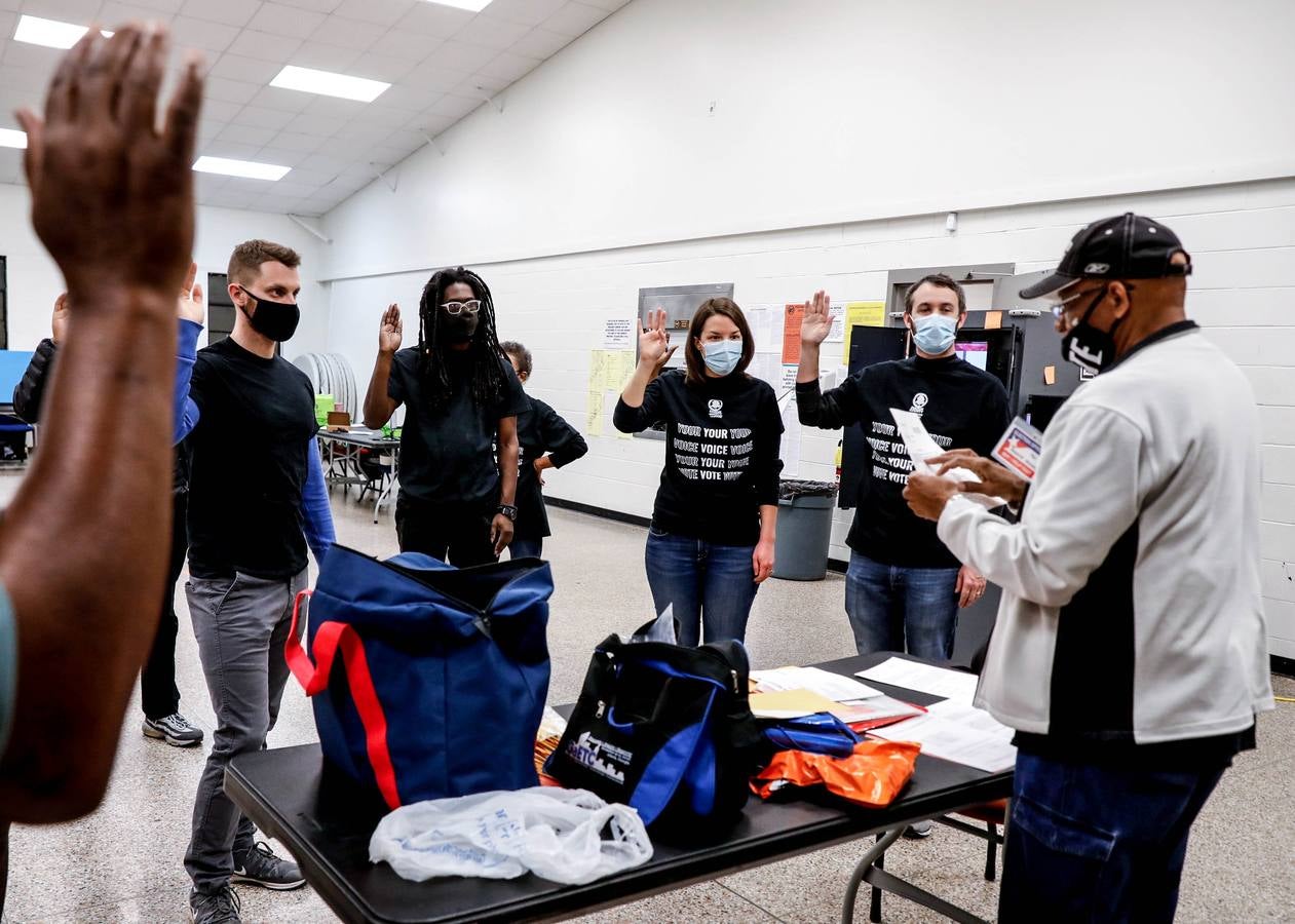 Los trabajadores electorales prestan juramento en la mesa de votación del condado de Fulton durante las elecciones en Atlanta.