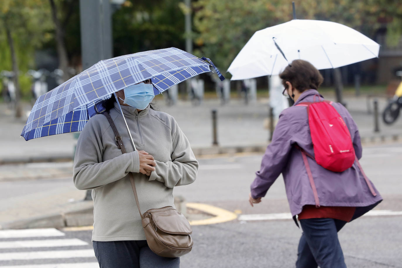 Dos personas caminan con sus paraguas por Valencia, protegiéndose de la lluvia que protagoniza la jornada del miércoles.