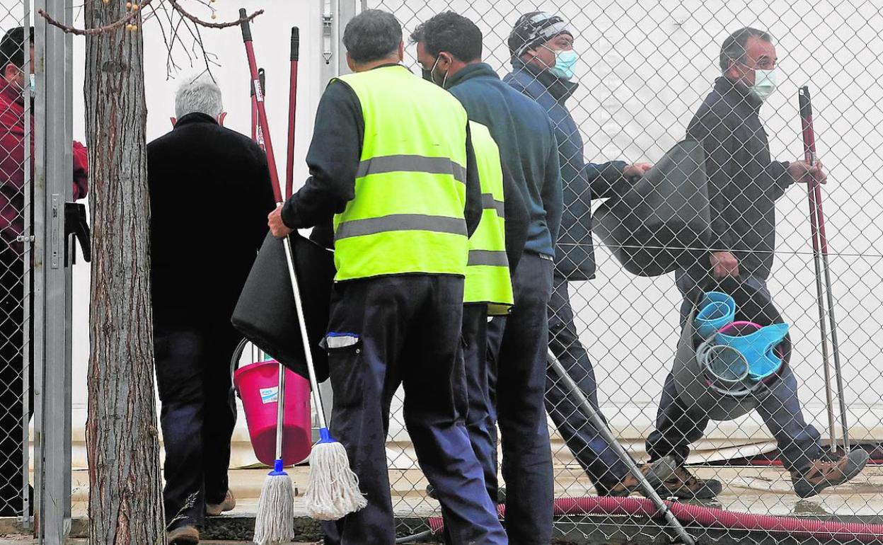 Operarios provistos con cubos y fregonas acceden a hospital de campaña de La Fe.