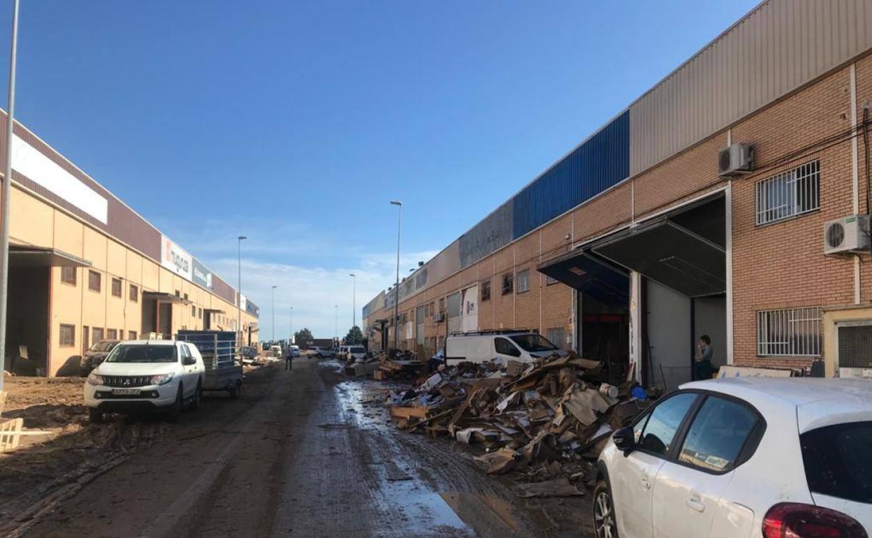 Una de las calles del polígono con residuos amontonados en las puertas de las naves. 