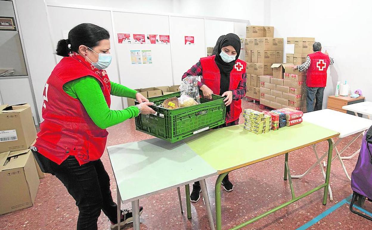 Voluntarios reparten paquetes de comida en Cáritas de Alcàsser. 