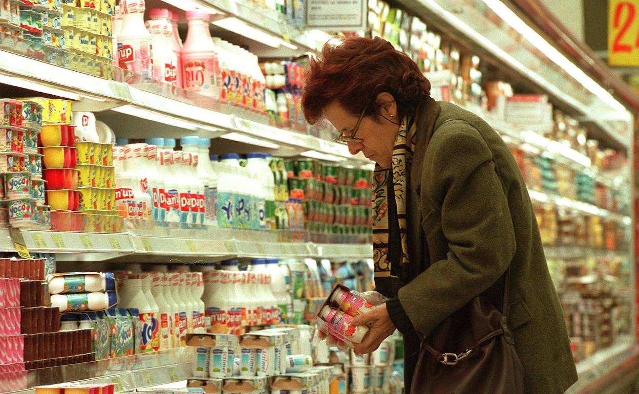 Una mujer comprando productos lácteos en un supermercado 