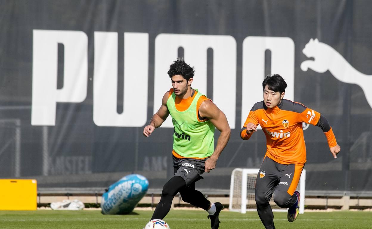 Guedes y Kang In pelean por un balón en la sesión preparatoria de ayer. 