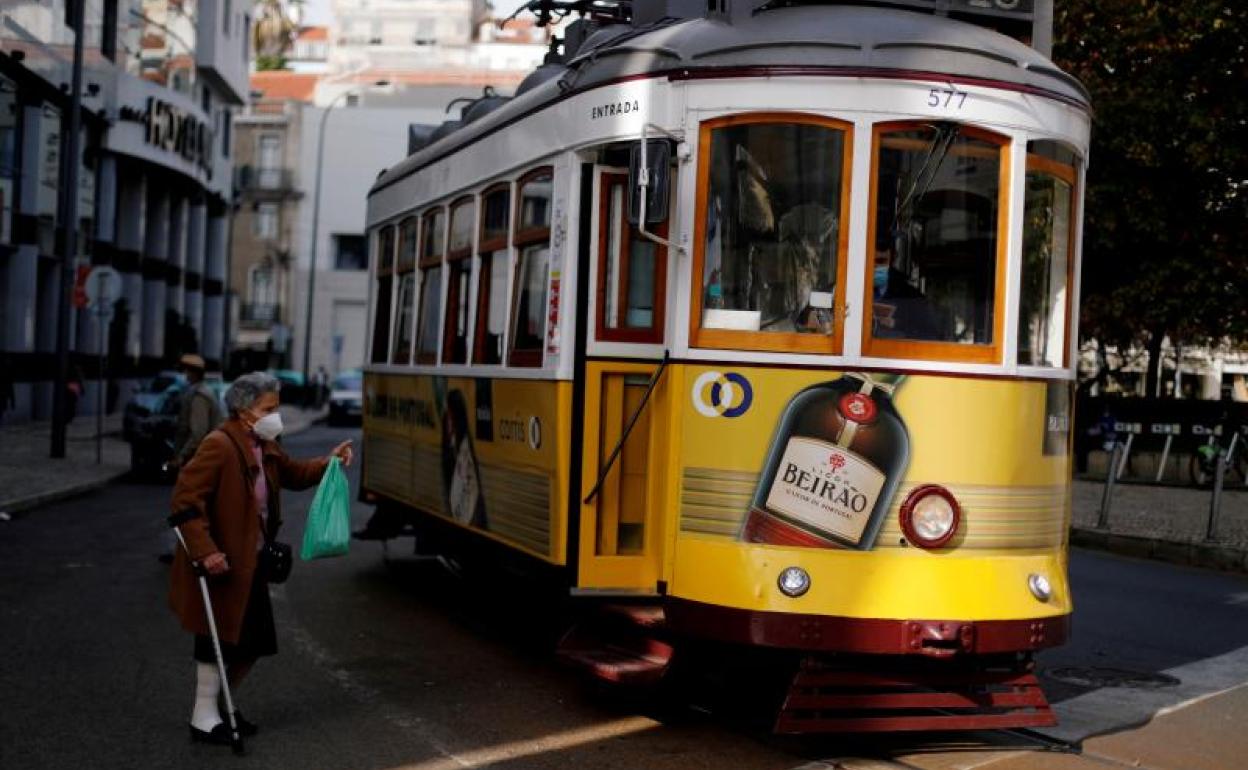 Una mujer intenta subir al tranvía en Lisboa. 