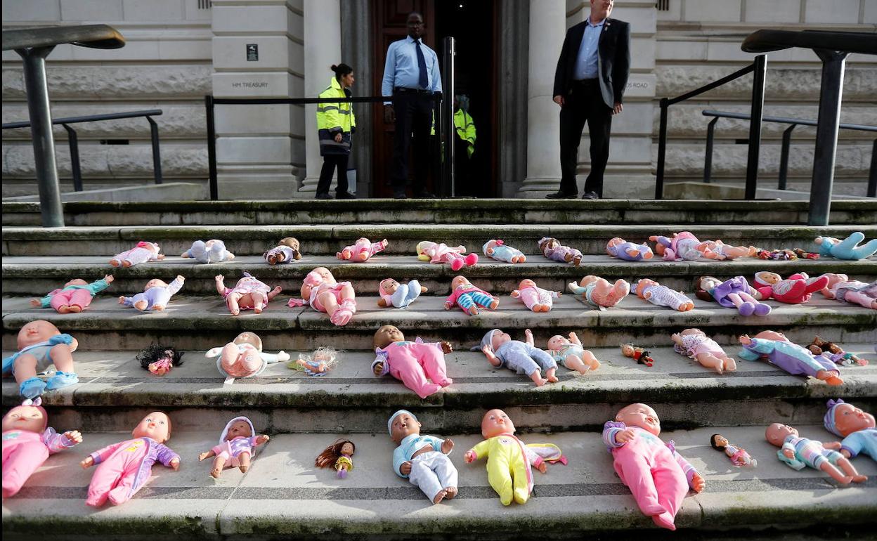 Muñecas colocadas en los escalones del Tesoro británico por activistas en protesta por el recorte en el presupuesto de la colaboración internacional.