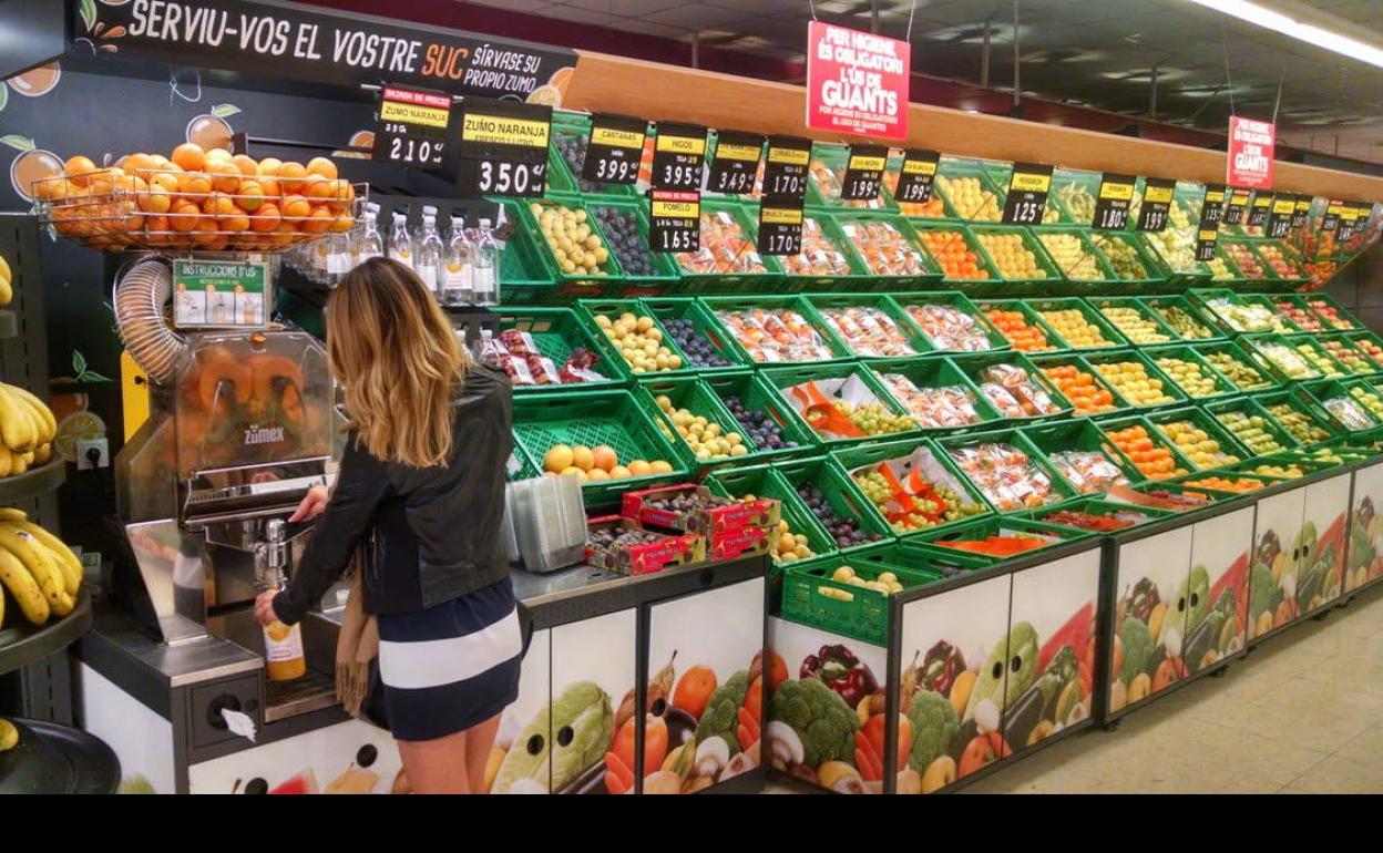 Una clienta exprime zumo de naranja en un supermercado.