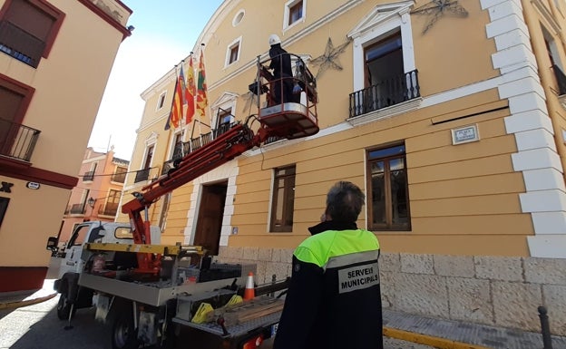 Imagen principal - Arriba, los operarios colocan la decoración en Oliva. A la izquierda, iluminación del nuevo árbol de 12 metros instalado en Paterna. A la derecha, las calles de Xàtiva, más iluminadas con el aumento del gasto en esta partida. 