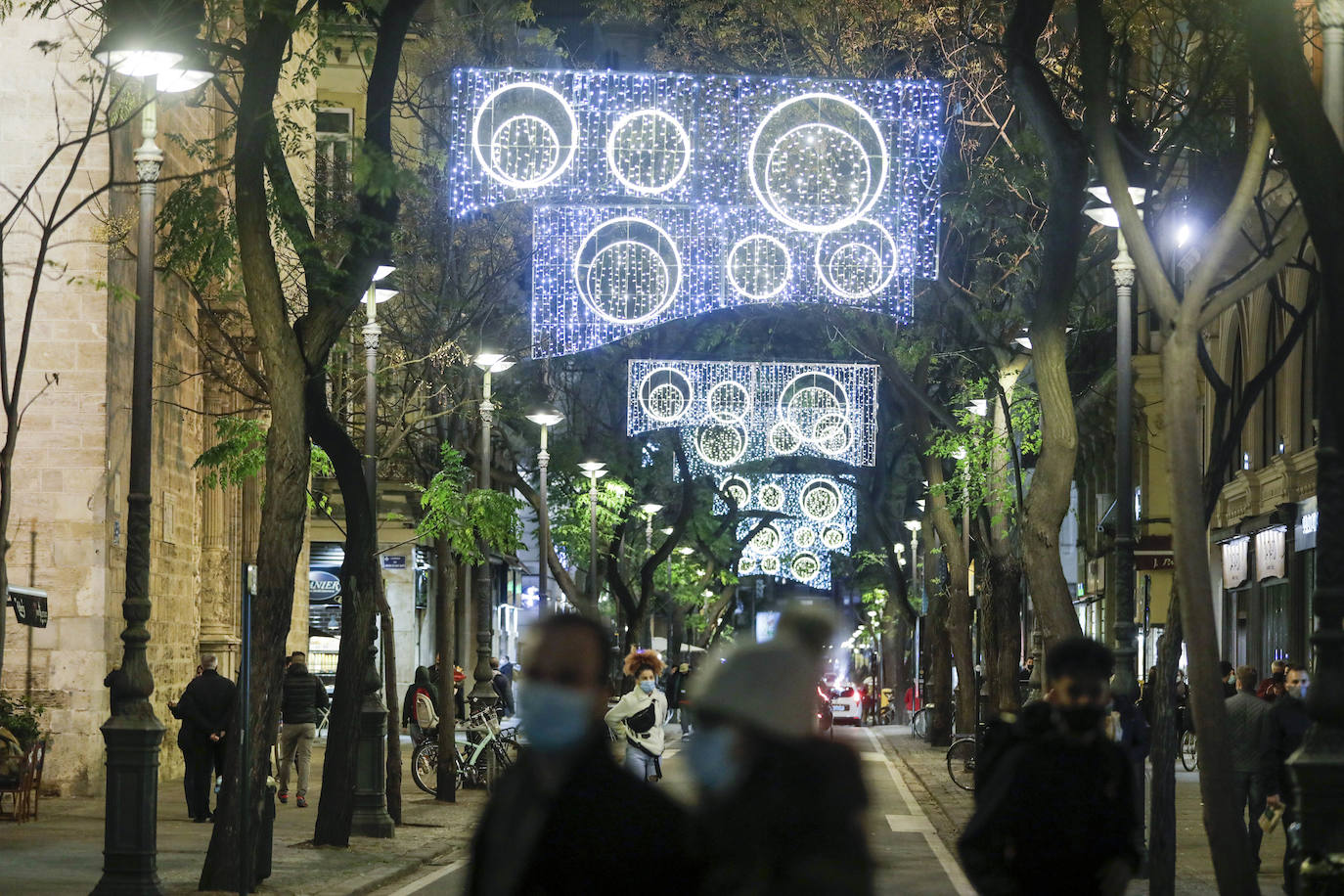 El alcalde Ribó ha asistido esta tarde al encendido en la plaza del Ayuntamiento, acompañado por las falleras mayores de Valencia, Consuelo Llobell y Carla García. La iluminación se estrena en la ciudad con quejas por el escaso gasto frente al aumento en otras ciudades para ayudar al comercio.