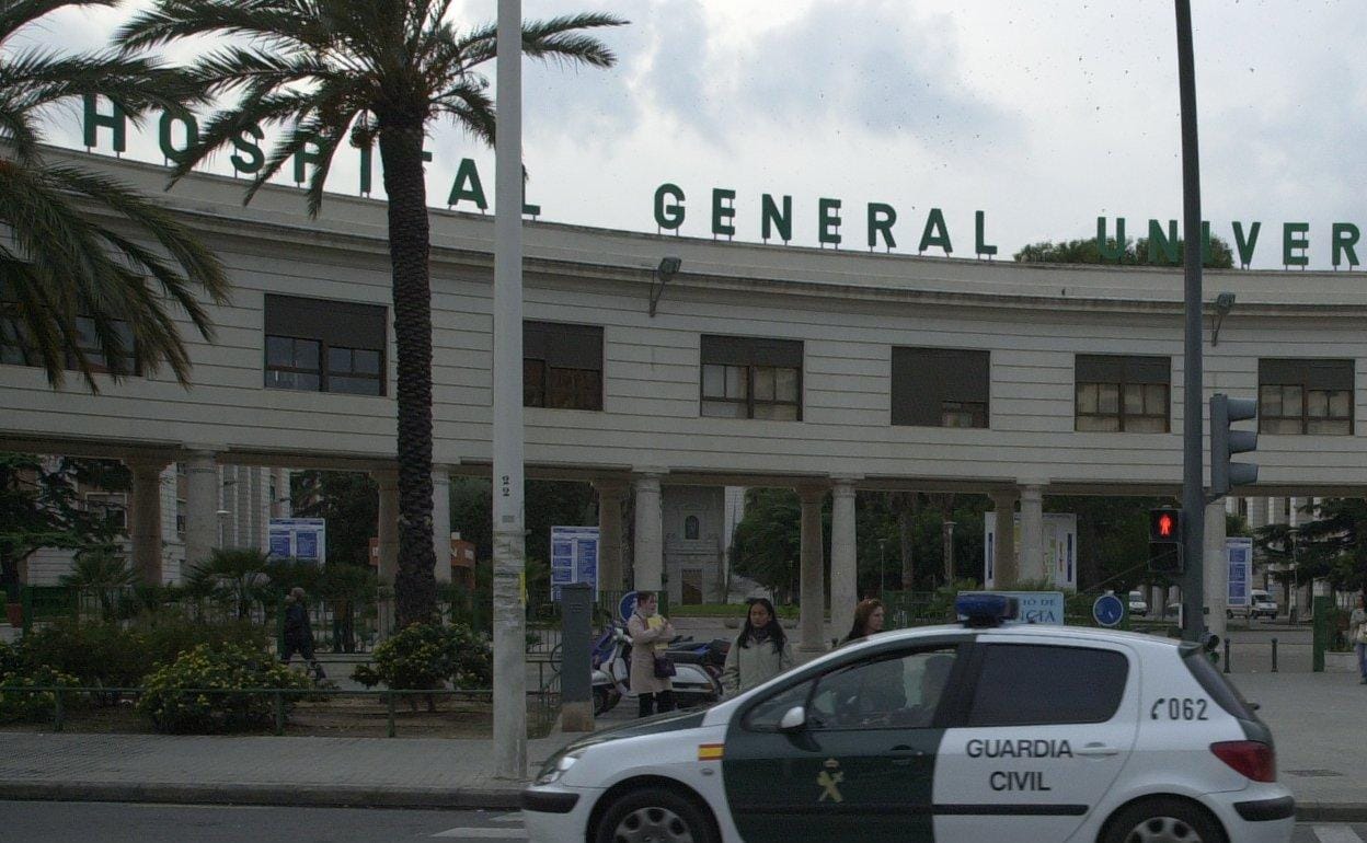 Un vehículo de la Guardia Civil circula junto al Hospital General de Valencia. 