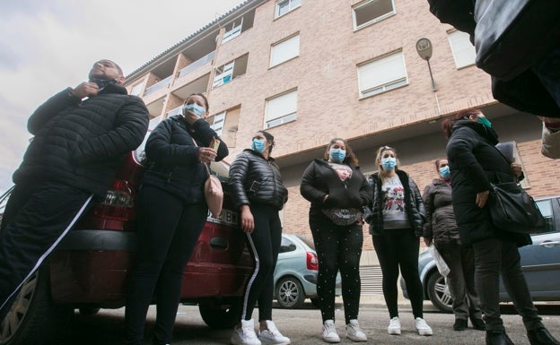 Galería. Varios de los afectados por el desahucio, esperando noticias ante el bloque de viviendas. 