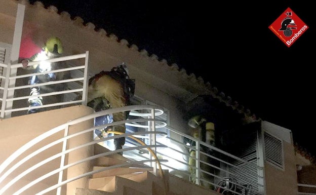 Los bomberos trabajan anoche en las tareas de extinción del incendio de la vivienda. 