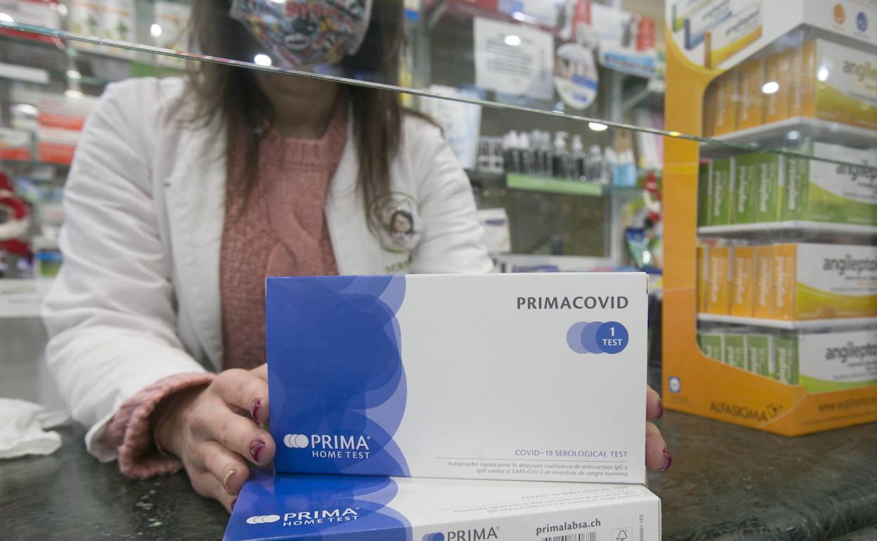 Una farmacéutica muestra las cajas del test del Covid-19. 