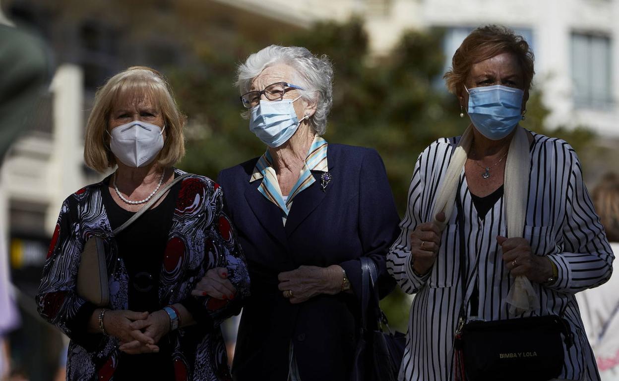 Tres mujeres caminando con mascarilla por Valencia. 