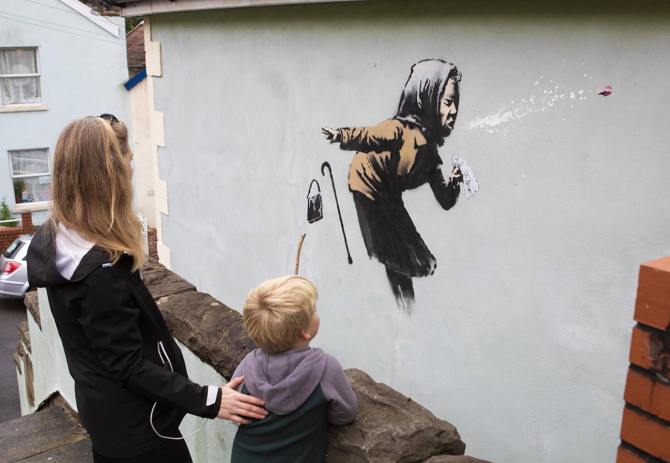 Bristol ha amanecido con una sorpresa: un nuevo mural del popular y misterioso artista urbano Banksy. La pintura titulada 'Aachoo!!' representa a una anciana estornudando, con su dentadura postiza volando, y apareció en la calle Vale Street durante la madrugada del jueves. 