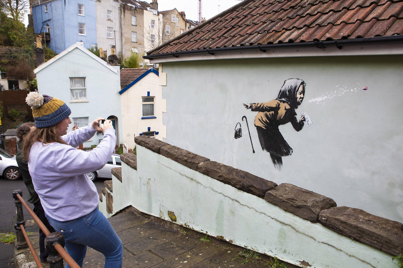 Bristol ha amanecido con una sorpresa: un nuevo mural del popular y misterioso artista urbano Banksy. La pintura titulada 'Aachoo!!' representa a una anciana estornudando, con su dentadura postiza volando, y apareció en la calle Vale Street durante la madrugada del jueves. 